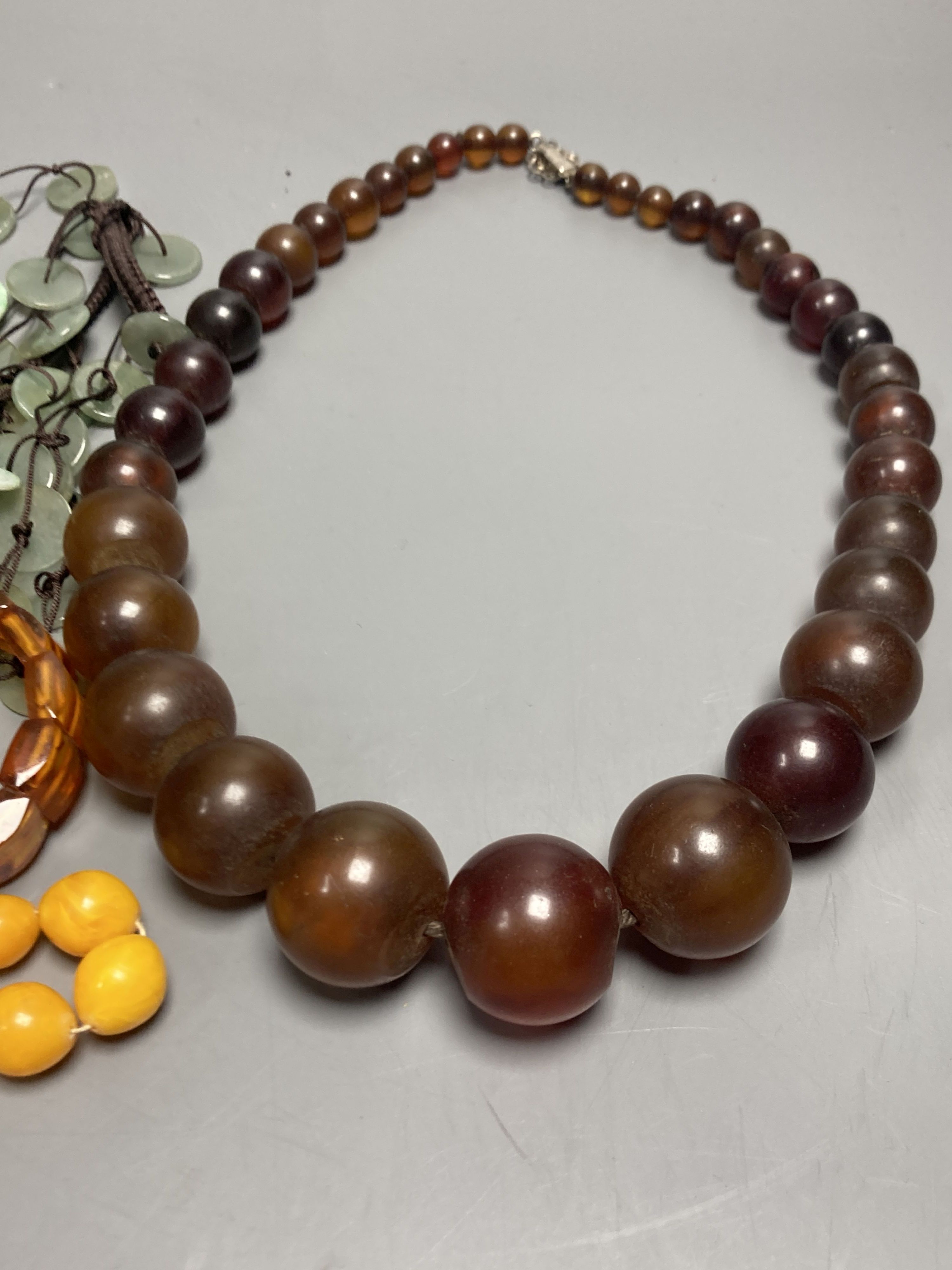 A pale yellow amber bead necklace, 56cm, gross 45 grams and other necklaces including simulated amber.